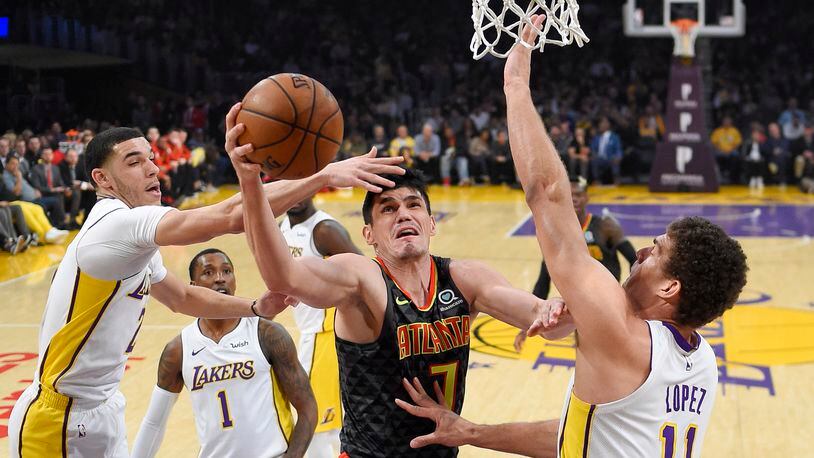 Atlanta Hawks forward Ersan Ilyasova, second from right, of Turkey, shoots as Los Angeles Lakers guard Lonzo Ball, left, guard Kentavious Caldwell-Pope, second from left, and center Brook Lopez defend during the first half of a basketball game, Sunday, Jan. 7, 2018, in Los Angeles. (AP Photo/Mark J. Terrill)