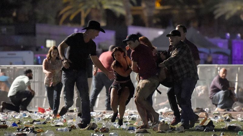People carry a wounded concert patron to safety at the Route 91 Harvest country music festival in Las Vegas on Oct. 1, 2017, after a gunman opened fire from his nearby hotel room. At least 59 people were killed and more than 500 were injured in the deadliest mass shooting in modern U.S. history.