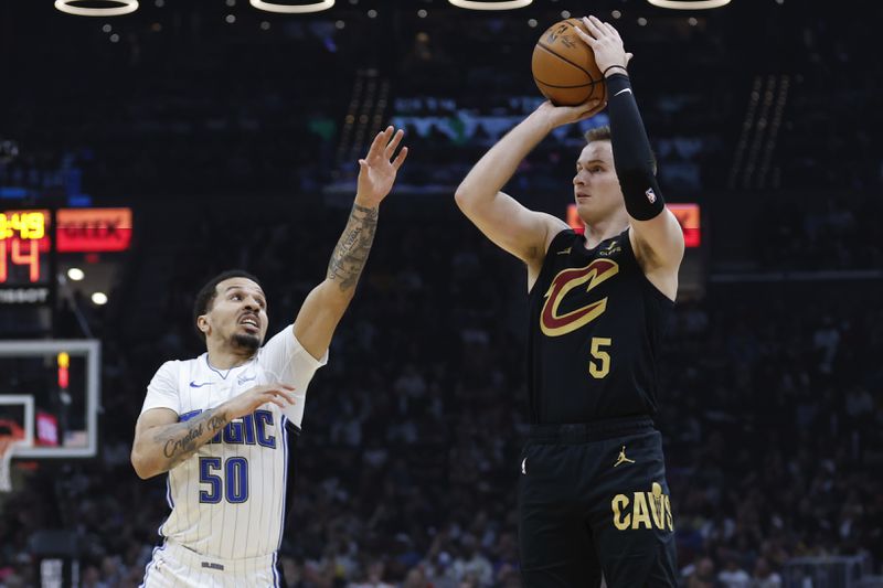 Cleveland Cavaliers guard Sam Merrill (5) shoots against Orlando Magic guard Cole Anthony (50) during the first half of Game 5 of an NBA basketball first-round playoff series, Tuesday, April 30, 2024, in Cleveland. (AP Photo/Ron Schwane)