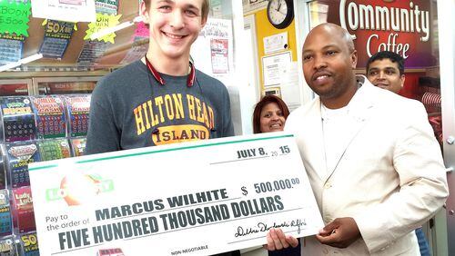 Lottery winner Marcus Wilhite (left) claims his $500K prize from Georgia Lottery sales representative Isaac Robinson.