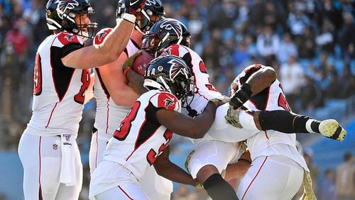 Falcons rookie running back Qadree Ollison (30) celebrates with teammates after scoring a touchdown - the first of his NFL career - against the Carolina Panthers Sunday, Nov. 17, 2019, at Bank of America Stadium in Charlotte.