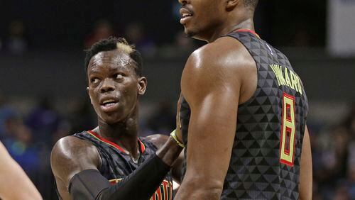 Atlanta Hawks' Dennis Schroder (17) tries to calm Dwight Howard (8) after Howard received a technical foul against the Charlotte Hornets in the second half of an NBA basketball game in Charlotte, N.C., Friday, Nov. 18, 2016. The Hornets won 100-96. (AP Photo/Chuck Burton)