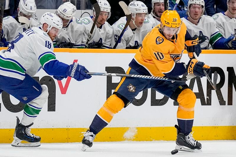Nashville Predators center Colton Sissons (10) tries to get the puck past Vancouver Canucks center Sam Lafferty (18) during the first period in Game 6 of an NHL hockey Stanley Cup first-round playoff series Friday, May 3, 2024, in Nashville, Tenn. (AP Photo/George Walker IV)
