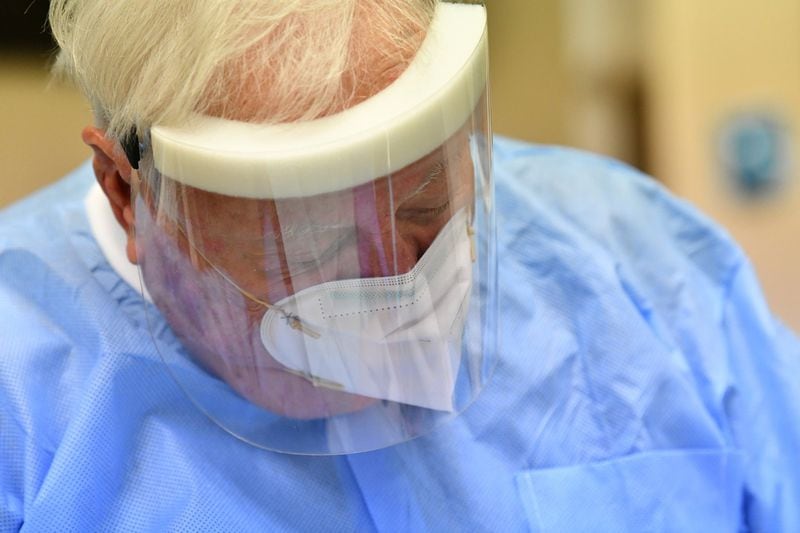 Dr. Roy Johnson, in full personal protective equipment, treats a patient at Windy Hill Dentistry in Smyrna. Georgia dentists had to shut down early in the coronavirus pandemic and now they’re being hit by skyrocking costs of PPE and other infection-control measures. Johnson is seeking to have losses covered through his business disruption insurance, rather than raising costs to patients. (Hyosub Shin / Hyosub.Shin@ajc.com)