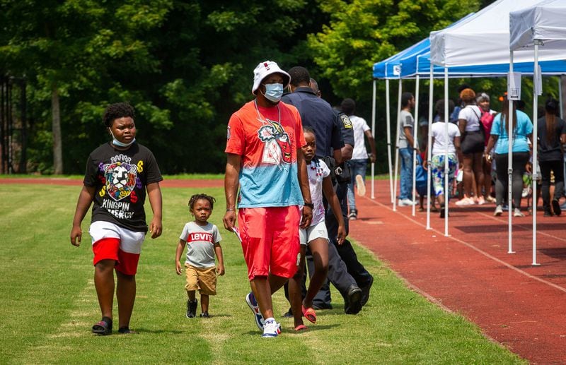 Families walk around to the different tents during the Family Fun Day at John Lewis Invictus Academy Saturday, July 24, 2021. STEVE SCHAEFER FOR THE ATLANTA JOURNAL-CONSTITUTION
