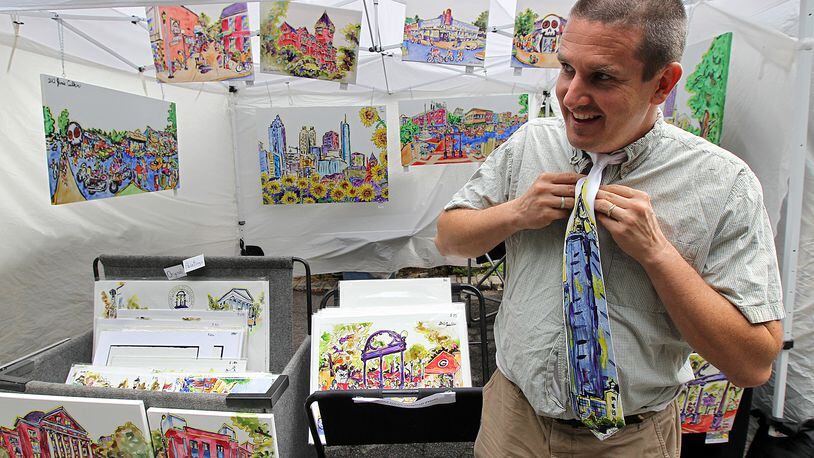Jamie Calkin, 42, Athens, who specializes in local scenes, suits up at his booth for the Piedmont Park Summer Arts & Crafts Festival on Sunday, August 19, 2012.