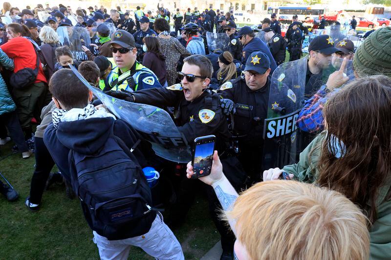 Police push back on demonstrators protesting the war in Gaza as they work to remove a non-sanctioned encampment on the campus of UW-Madison in Madison, Wis., on Wednesday, May 1, 2024. (John Hart/Wisconsin State Journal via AP)