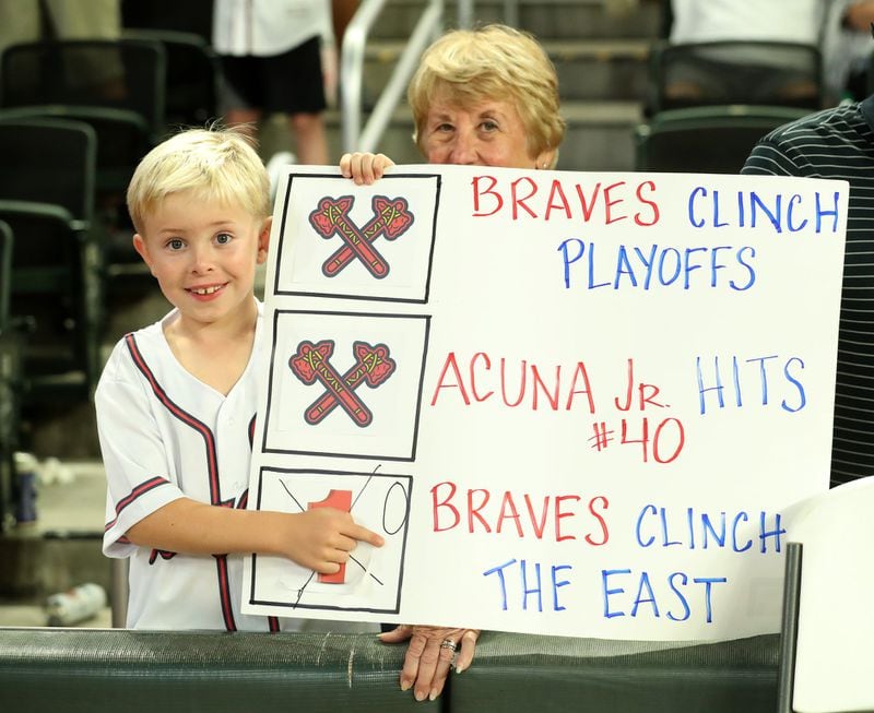 An Atlanta Braves fan holds a sign in honor of center fielder Ronald Acuna (not pictured) after the Braves’ 6-0 win against the San Francisco Giants to clinch the NL East division at Sun Trust Park Friday, Sept. 20 in Atlanta. (JASON GETZ/SPECIAL TO THE AJC)