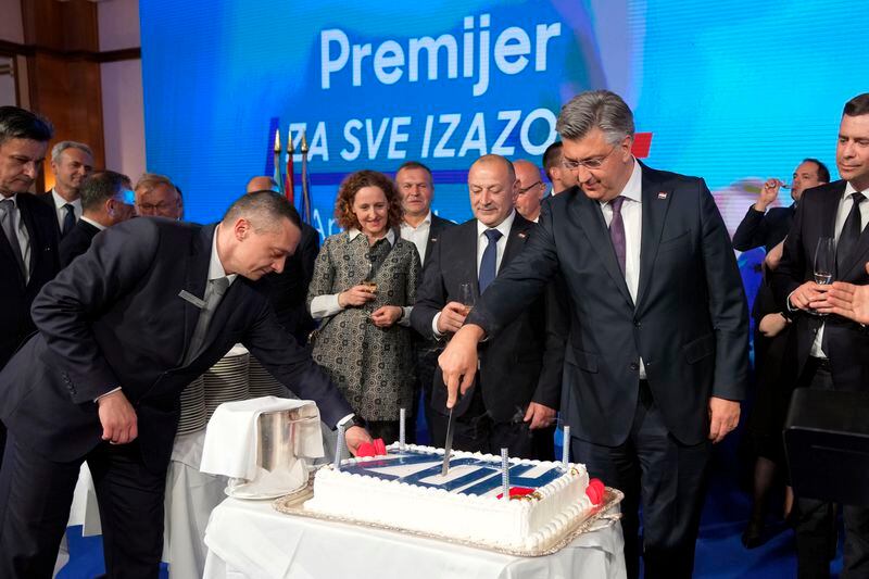 Prime Minister incumbent Andrej Plenkovic cuts the cake after claiming victory in a parliamentary election in Zagreb, Croatia, Thursday, April 18, 2024. Croatia's governing conservatives convincingly won a highly contested parliamentary election Wednesday, but will still need support from far-right groups to stay in power, according to the official vote count. The election followed a campaign that centered on a bitter rivalry between the country's president and prime minister. (AP Photo/Darko Vojinovic)