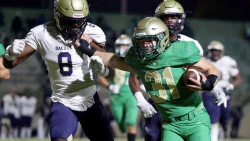 Buford running back Eli Parks (31) runs a fake punt for a first down against Dacula defensive lineman Festus Davies (8) in the first half at Buford Friday.