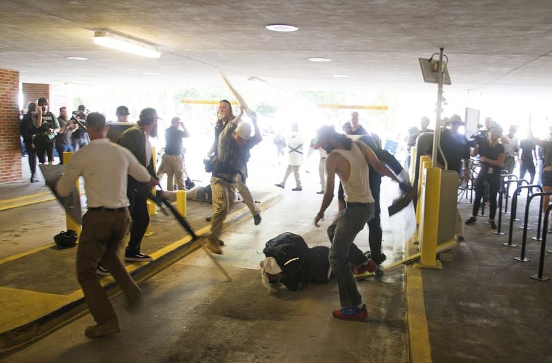 In this Aug. 12, 2017 photo, DeAndre Harris, is assaulted in a parking garage beside the Charlottesville police station after a white nationalist rally was dispersed by police, in Charlottesville, Va. (Zach D. Roberts via AP)