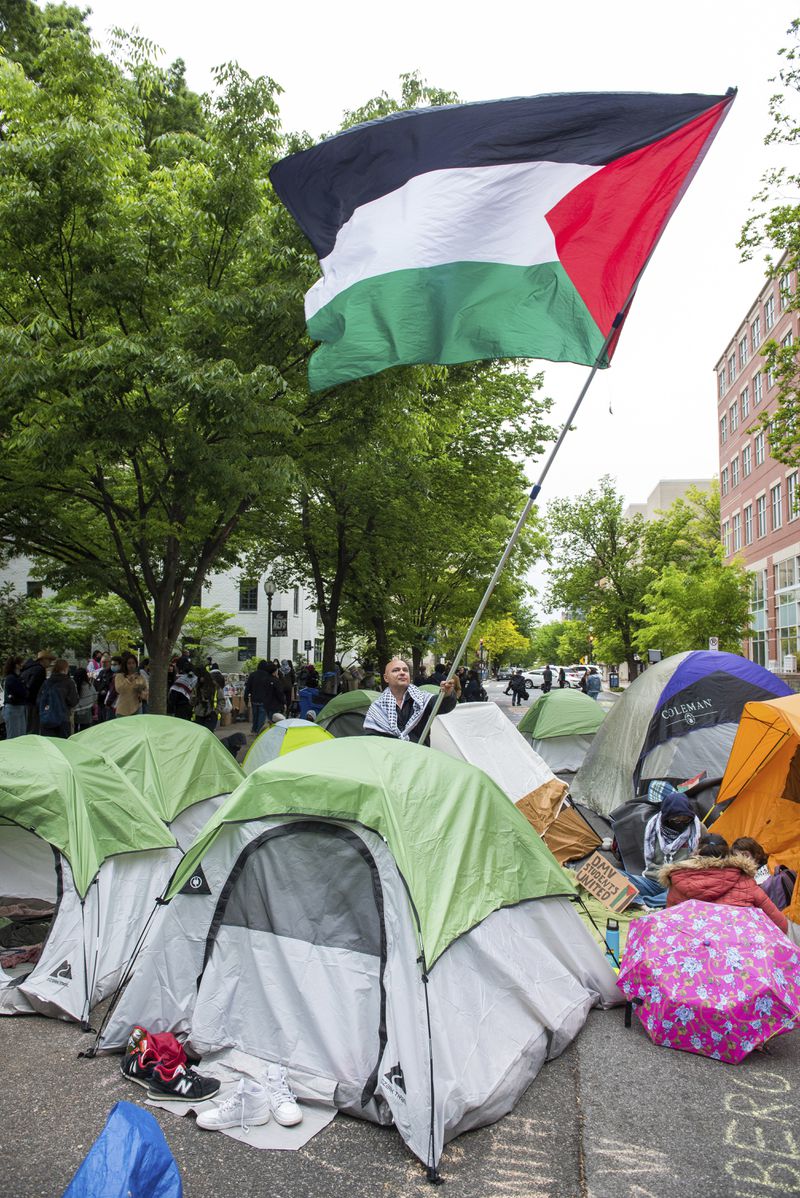 The Palestinian flag is flown during a protest of the Israel-Hamas war at George Washington University in Washington, Saturday, April 27, 2024. Protests and encampments have sprung up on college and university campuses across the country to protest the war. (AP Photo/Cliff Owen)