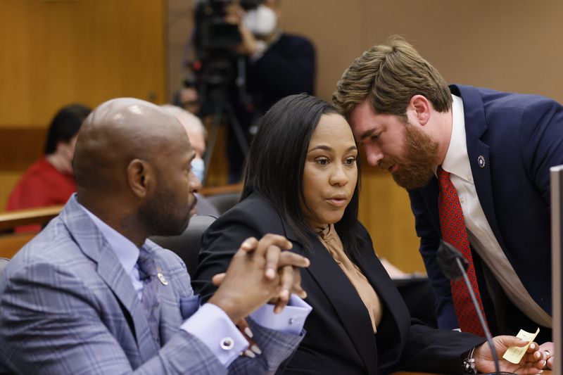Fulton County D.A. Fani Willis (center) confers with colleagues Nathan Wade (left) and Donald Wakeford (right) during a Jan. 24, 2023, hearing before Fulton Superior Court Judge Robert McBurney. Miguel Martinez / miguel.martinezjimenez@ajc.com