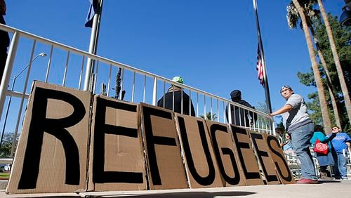 A sign welcoming Syrianrefugees is placed at the entrance to the office of the Arizona governor during a rally at the Arizona Capitol Tuesday, Nov. 17, 2015, in Phoenix. Arizona Gov. Doug Ducey has joined a growing number of governors calling for an immediate halt to the placement of any new refugees in the wake of terrorist attacks in Paris. The U.S. State Department says Arizona has received 153 Syrianrefugees so far this year.