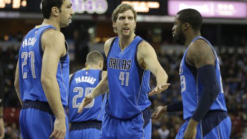Dallas Mavericks' Zaza Pachulia, left, of Georgia, and Dirk Nowitzki, center, of Germany, congratulate teammate Wesley Matthews after he scored against the Sacramento Kings during the first quarter of an NBA basketball game in Sacramento, Calif., Monday, Nov. 30, 2015.(AP Photo/Rich Pedroncelli)