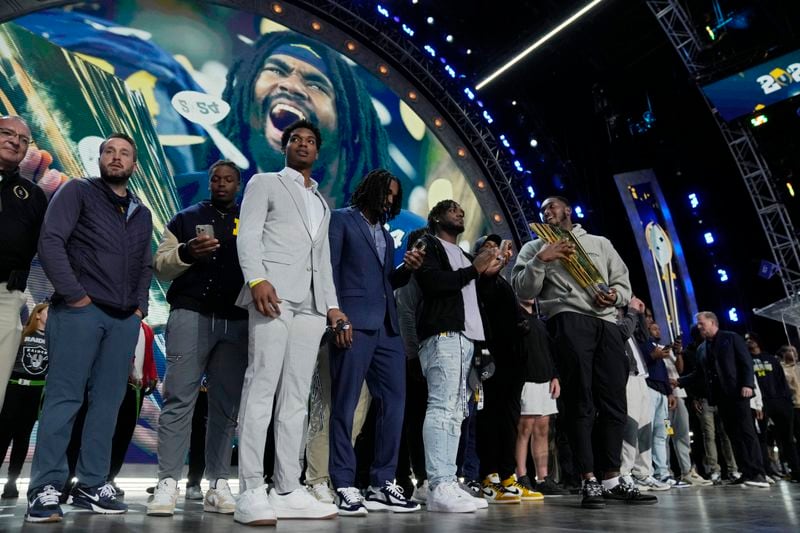 Michigan football players stand on stage during the second round of the NFL football draft, Friday, April 26, 2024, in Detroit. (AP Photo/Jeff Roberson)