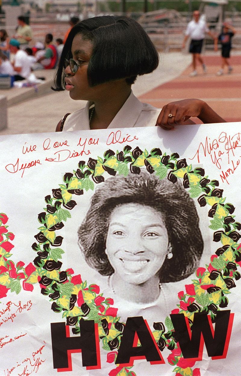 Fallon Stubbs holds onto banner memorializing her mother, Alice Hawthorne at Centennial Park in this 1997 AJC file photo. Hawthorne was killed in 1996 by a bomb at Centennial Olympic Park. 