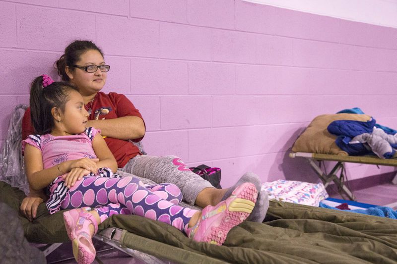 10/10/2018 -- Albany, Georgia -- Lorena Lozano sits with her daughter Sophia Lozano while taking shelter from Hurricane Michael at New Birth Fellowship Church in Albany, Wednesday, October 10, 2018. Hurricane Michael was ranked as a Category 4 storm before making landfall in the Florida Panhandle and South Georgia. (ALYSSA POINTER/ALYSSA.POINTER@AJC.COM)