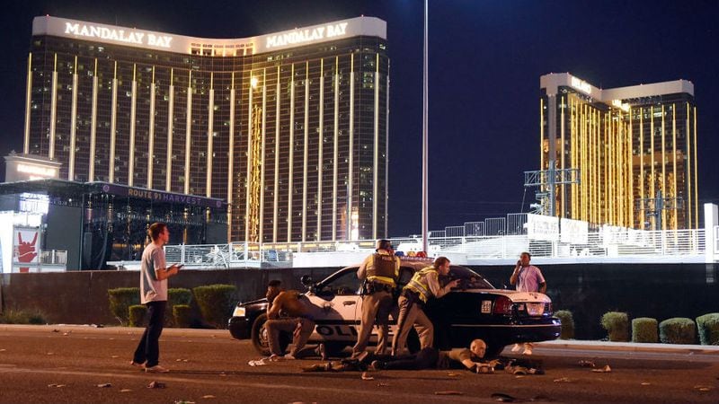 Las Vegas police officers stand guard outside the Route 91 Harvest country music festival on Oct. 1, 2017, after a gunman opened fire from his hotel room in the Mandalay Bay Resort and Casino, pictured in the background. At least 59 people were killed and more than 500 were injured in the deadliest mass shooting in modern U.S. history.