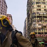 Firefighters walk past a building called New Lucky House where a fire started in Hong Kong, Wednesday, April 10, 2024. (AP Photo/Louise Delmotte)