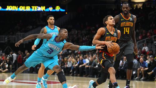Hawks guard Trae Young drives the lane as Hornets guard Terry Rozier (3) defends during the first half of Monday's game in Atlanta. (AP Photo/John Amis)