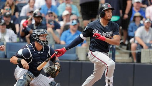 Atlanta Braves' Johan Camargo, right, follows through with a ground rule double to score Ozzie Albies during the first inning of a baseball spring exhibition game against the New York Yankees, Friday, March 2, 2018, in Tampa, Fla. At left is New York Yankees catcher Gary Sanchez. (AP Photo/Lynne Sladky)