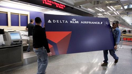 Travelers walking into Minneapolis-St. Paul International Airport on Tuesday saw the Delta Air Lines name splashed across a terminal that was once dominated by Northwest Airlines. Here, Shannon King (left) and Brian Vosberg carry a new Delta sign to a ticket counter Monday.