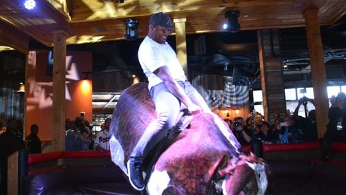Atlanta Braves Hall of Famer Andruw Jones rides the mechanical bull at the PBR Atlanta, a cowboy-style bar opening in the Battery Atlanta on May 5, 2017. The mechanical bull "Druw" is named after the 10-time Gold Glove winner.