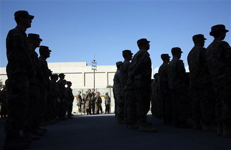 U.S. service members stand during a ceremony on the thirteenth anniversary of the 9/11 terrorist attacks in front of the World Trade Center Memorial, at Bagram Airfield, Afghanistan Thursday, Sept. 11, 2014. (AP Photo/Massoud Hossaini)