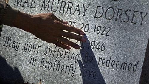 Bobby Howard touches a memorial tombstone for Moore's Ford lynching victim Mae Murray Dorsey during a visit to the Zion Hill Cemetery in Monroe, Ga., on Monday, Feb. 26, 2001.