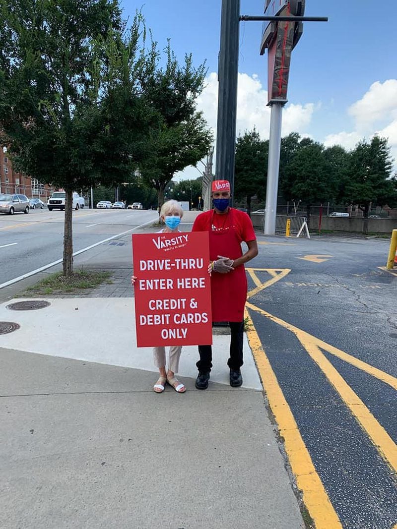 Nancy Simms, the Varsity's CEO and daughter of late founder, Frank Gordy, stands with carhop Demareo Collins directing traffic at the Midtown restaurant's new drive-thru. / Varsity Facebook page