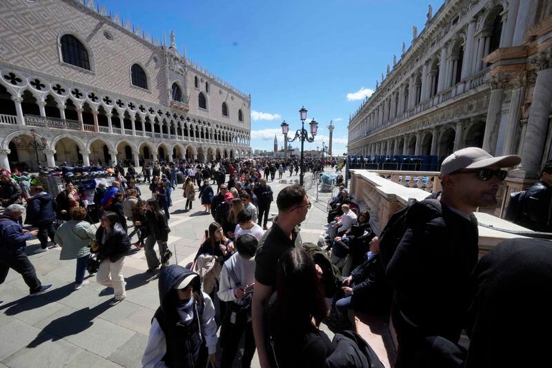 Tourists line up to enter at the at St.Mark bell tower in Venice, Italy, Thursday, April 25, 2024. The fragile lagoon city of Venice begins a pilot program Thursday to charge daytrippers a 5 euro entry fee that authorities hope will discourage tourists from arriving on peak days. (AP Photo/Luca Bruno)