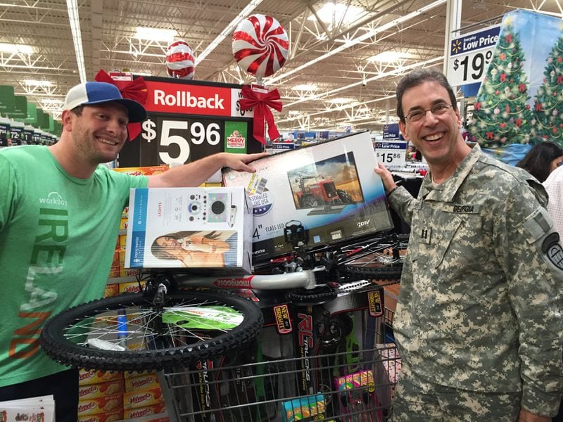 Matt Dale of Marietta stocked up for foster kids and posed with his stash with Clark Howard. CREDIT: Rodney Ho/rho@ajc.com