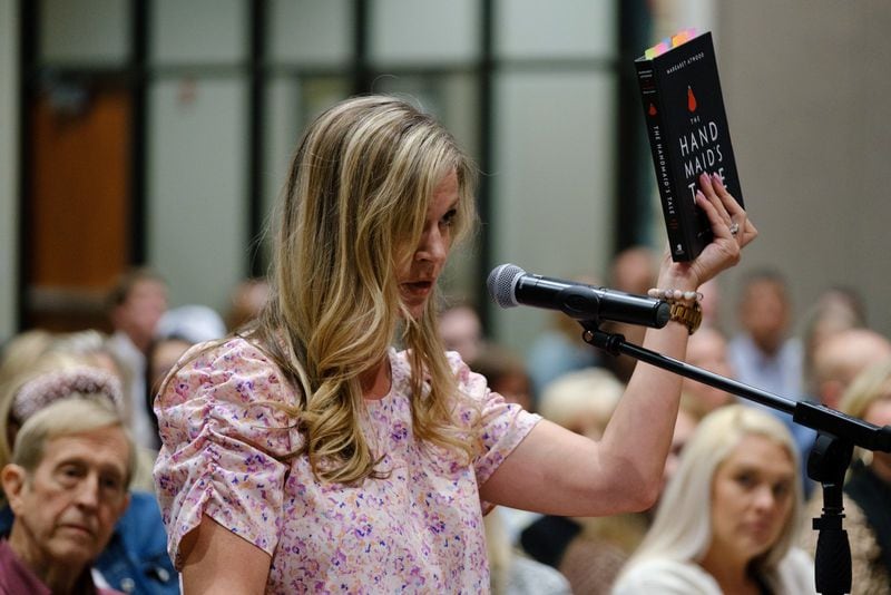 Chelle Brown holds a graphic novel adaptation of Margaret Atwood’s The Handmaid’s Tale while speaking at a Cherokee County school board meeting in Canton on Thursday, April 21, 2022. Brown and some other parents advocate for removing books they deem objectionable from Cherokee County schools. (Arvin Temkar / arvin.temkar@ajc.com)