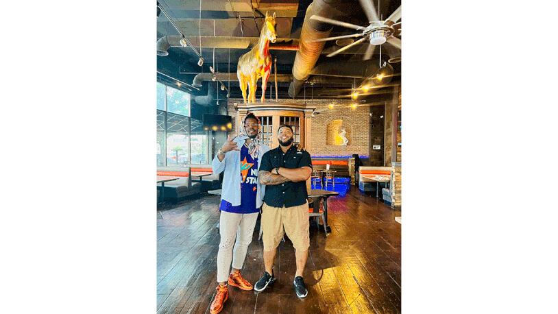 Cam and C.J. Newton pose in their new restaurant, Smokey Stallion.