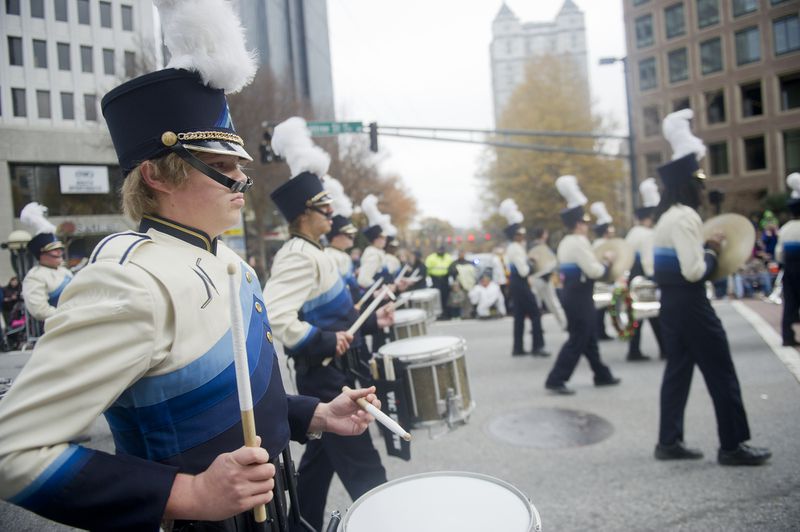 Newnan High School's Dalton Yarbrough (left) plays the snare drum as he marches down Peachtree Street during the 33rd annual Children's Christmas Parade in Atlanta on Saturday, December 7, 2013. Over 300,000 people were expected to attend the parade that wound its way down Peachtree Street in Midtown. Proceeds from the parade help to fund programs and equipment to serve the patients and families at Children’s Healthcare of Atlanta. JONATHAN PHILLIPS / SPECIAL