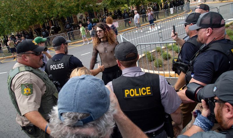 A counterprotester who entered a pro-Trump rally is quickly surrounded by police officers in Dahlonega on Saturday, September 14, 2019.   STEVE SCHAEFER / SPECIAL TO THE AJC