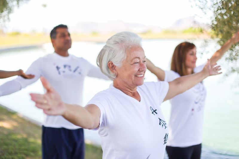 Tai chi participants practice a set of movements under the direction of a Body & Brain Yoga Tai Chi instructor.