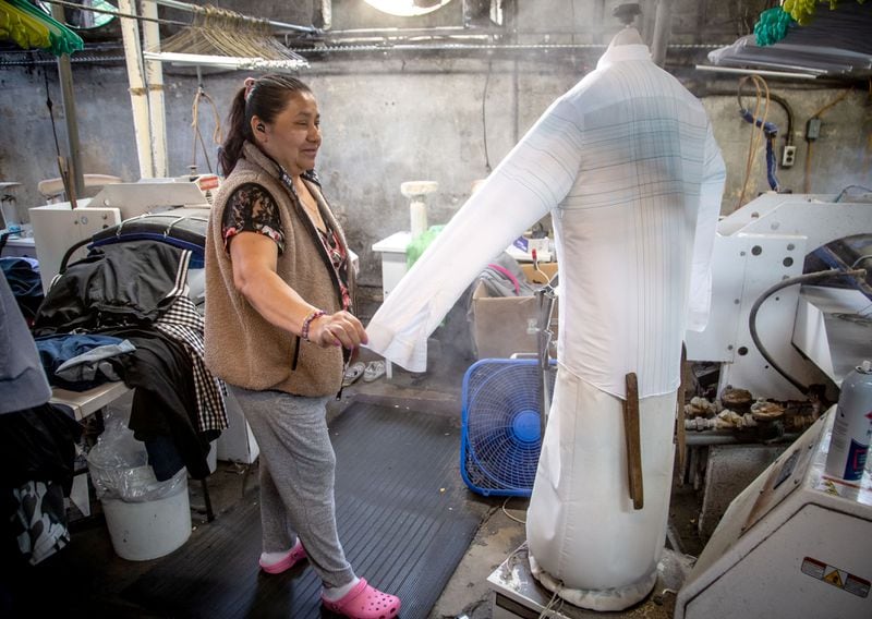 Rosa Hernandez dries a shirt while working at Sig Samuels Dry Cleaners. The coronavirus has changed the way people dress. STEVE SCHAEFER FOR THE ATLANTA JOURNAL-CONSTITUTION