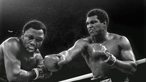 In this Oct. 1, 1975 file photo, spray flies from the head of challenger Joe Frazier, left, as heavyweight champion Muhammad Ali connects with a right in the ninth round of their title fight in Manila, Philippines. (AP Photo/Mitsunori Chigita, File)