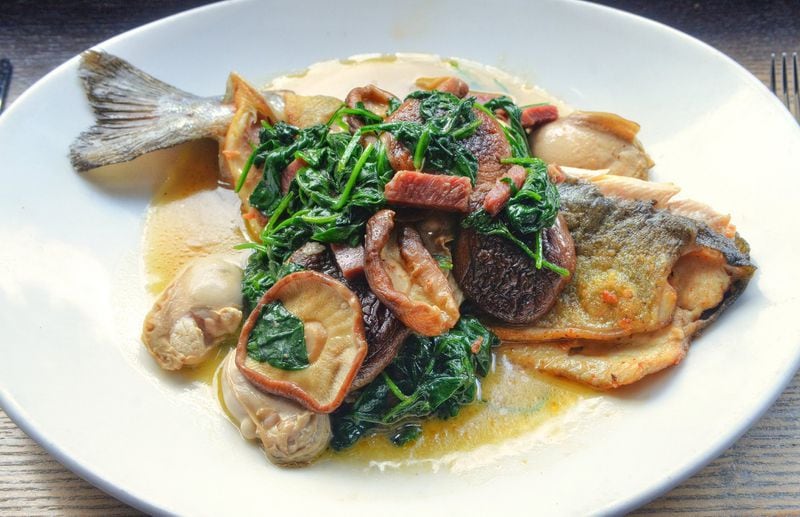 Rainbow Trout with Swiss Chard, Oysters and Country Ham. Recipes are for New Orleans-style preparations for fish and seafood by chef Tenney Flynn, who lives in New Orleans, but who was born and raised in Stone Mountain, Georgia, and got his start with the Buckhead Life Restaurant Group. He has a new book out on fish and seafood, which is where the recipes come from. All photos taken Friday July 26, 2019 at Kyma in Buckhead. Food styling by Tenney Flynn. (Chris Hunt Photography)