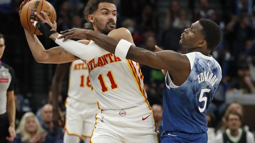 Atlanta Hawks guard Trae Young (11) works to keep the ball away from Minnesota Timberwolves guard Anthony Edwards (5) during the first quarter of an NBA basketball game Friday, April 12, 2024, in Minneapolis. The Hawks fell 109-106.   (AP Photo/Bruce Kluckhohn)