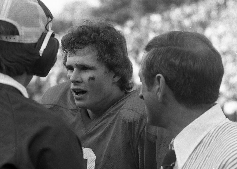 Georgia QB Buck Belue (left) confers with coach Vince Dooley during a game. AJC archive