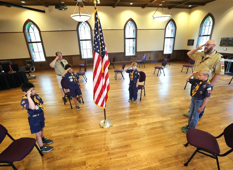 Cub Scouts Pack 625 members Guy Stearns, Collin Mervis, Robert Walker, and Jamison Kind recite the Pledge of Allegiance for a virtual Memorial Day ceremony Woodstock will air online Monday. Curtis Compton ccompton@ajc.com