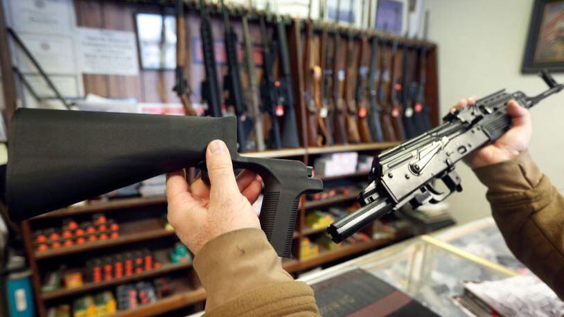 A bump stock device, (left) that fits on a semi-automatic rifle to increase the firing speed, making it similar to a fully automatic rifle, is shown next to a AK-47 semi-automatic rifle, (right) at a gun store in Salt Lake City, Utah.