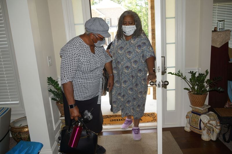 JULY 17, 2020 — Janice Cockfield (right) holds on to her sister Drucilla Burgess as they enter Janice's house in South Fulton for the first time since Janice was hospitalized for 110 days because of COVID-19. (Credit: Janese Cockfield / Contributed)