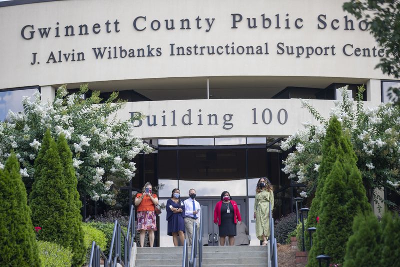Gwinnett County Public School administration listens as demonstrators speak during a rally created by the Gwinnett Educators for Equity and Justice outside of the Gwinnett County Public School building in Suwanee, on July 20. (ALYSSA POINTER / ALYSSA.POINTER@AJC.COM)