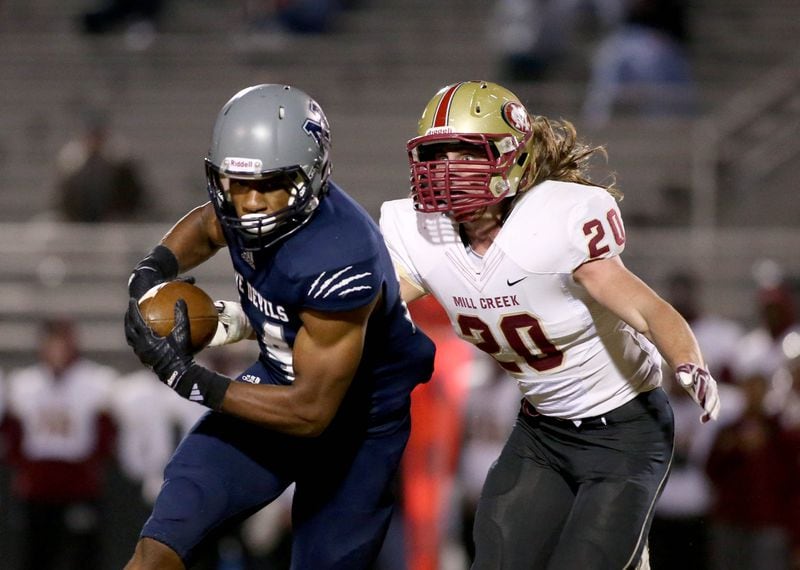 Norcross wide receiver Jared Pinkney (14) makes a move after a catch as Mill Creek linebacker Tyler Voyles (20) makes the tackle in the first half of their game Friday in Norcross, Ga., October 31, 2014. PHOTO / JASON GETZ