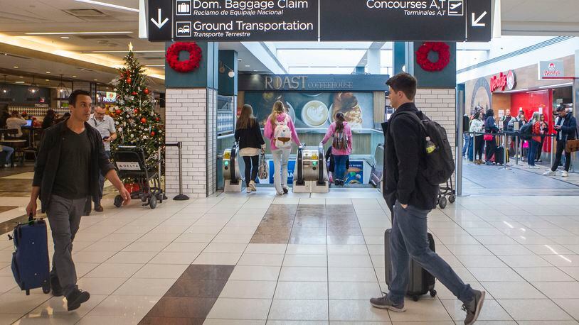 Travelers walk through the Hartsfield-Jackson international airport on Monday, December 9, 2022. Several retail and concession spaces are up for lease at the airport. CHRISTINA MATACOTTA FOR THE ATLANTA JOURNAL-CONSTITUTION.