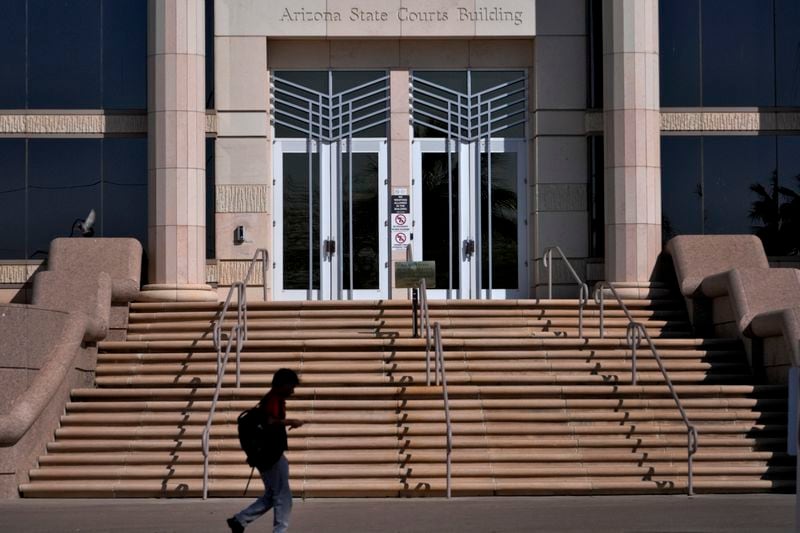 A person walks past the Arizona Supreme Court building, Wednesday, April 10, 2024, in Phoenix. The Arizona Supreme Court ruled Tuesday that the state can enforce its long-dormant law criminalizing all abortions except when a mother's life is at stake. (AP Photo/Matt York)